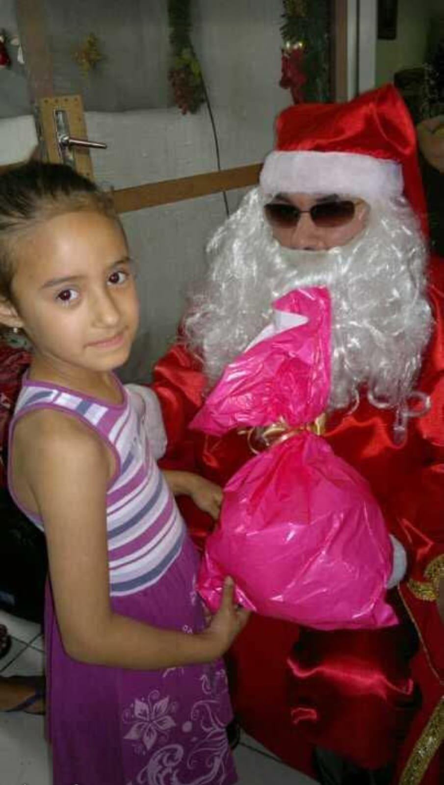 Papai Noel entrega um presente a uma menina
