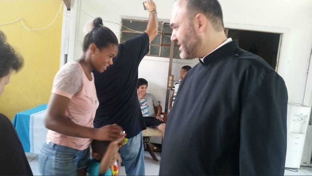Jovem recebe presente do sacerdote