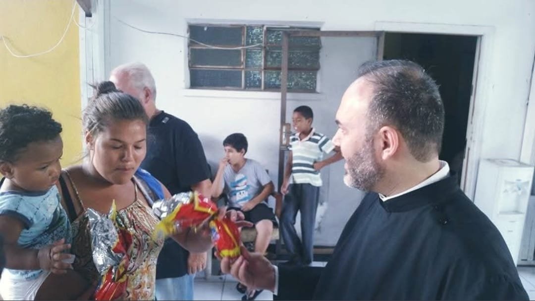 Mãe e filho recebem presente do sacerdote