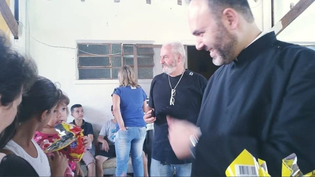 Sacerdote conversa com as famílias durante a entrega