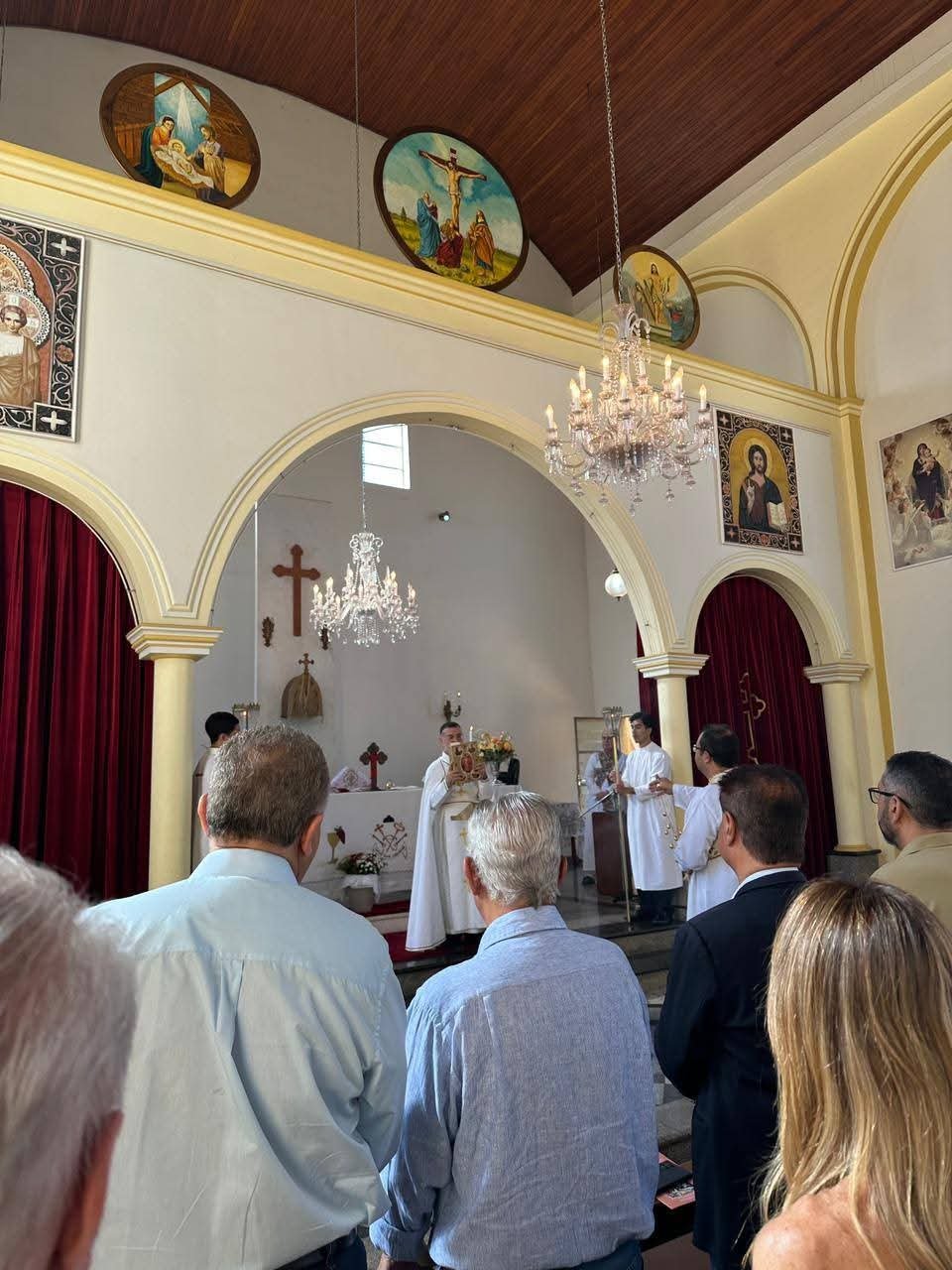 Nave da igreja com os fiéis de pé durante a Divina Liturgia, com o altar ao fundo