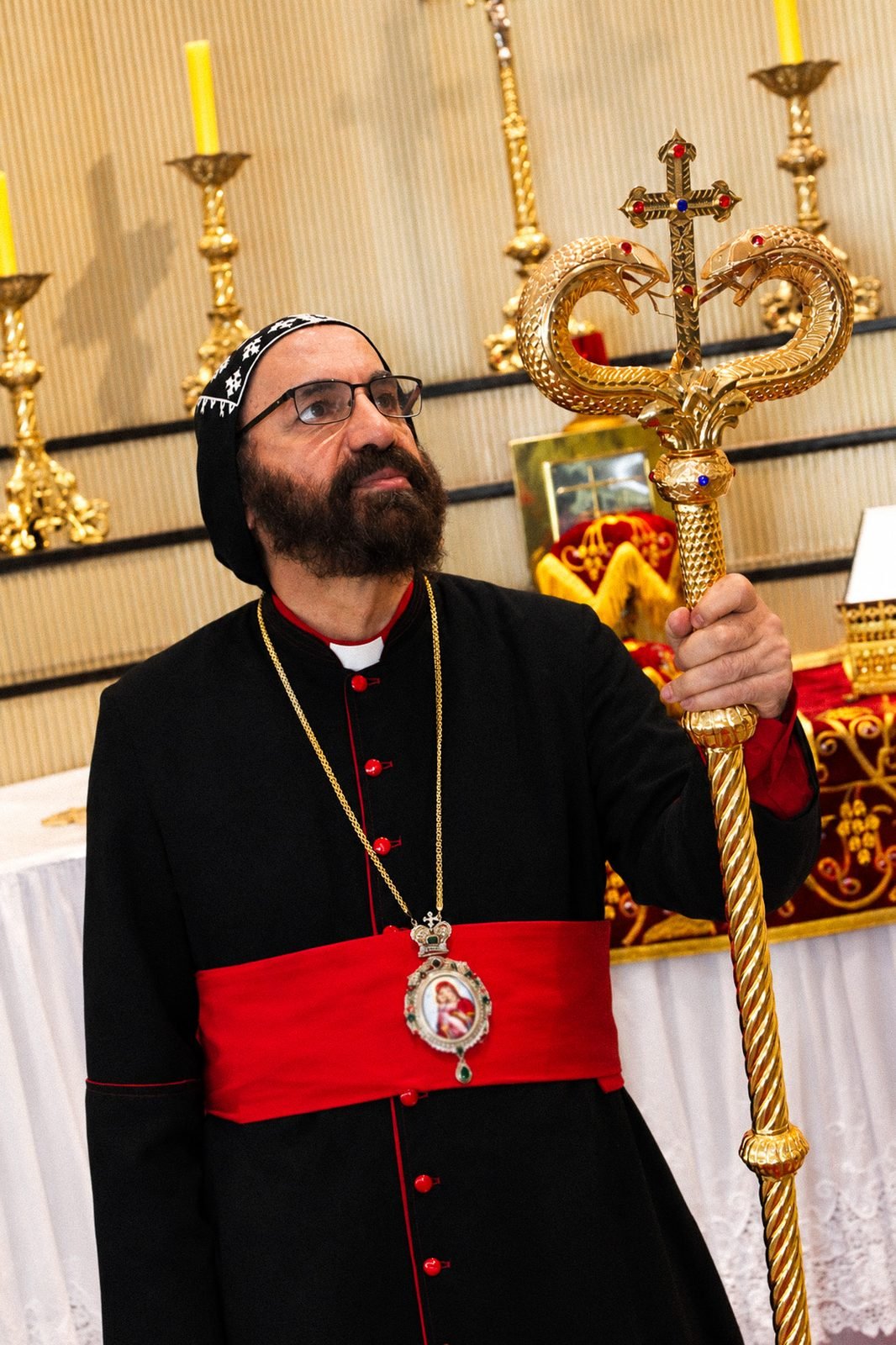O bispo com o báculo ao lado do altar